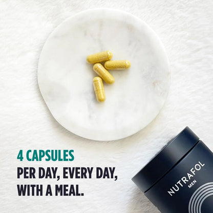Yellow capsules on a white plate with Nutrafol container below, on a white background